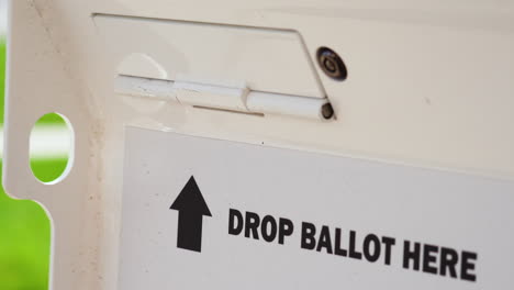 drop ballot here sign with arrow and slot for mail-in election voting box close up