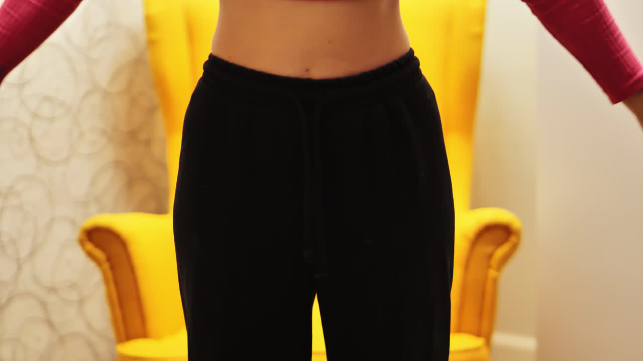 Evening home fitness with woman lifting pink dumbbells in soft warm light