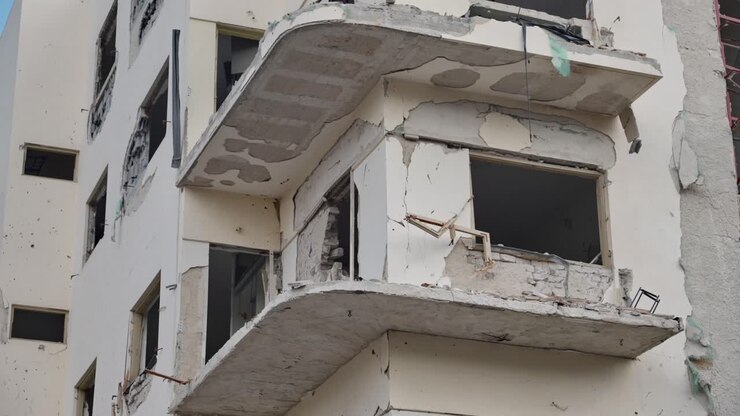 Edificio residenziale. Finestre rotte, muri crepati, barre di armatura esposte e balconi distrutti, servizi giornalistici, conseguenze di conflitti, risposta a disastri, ricostruzione e storie umanitarie. Ingenti danni da esplosione