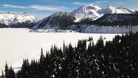 grandiose aerial shot of snow covered frozen garibaldi lake in winter