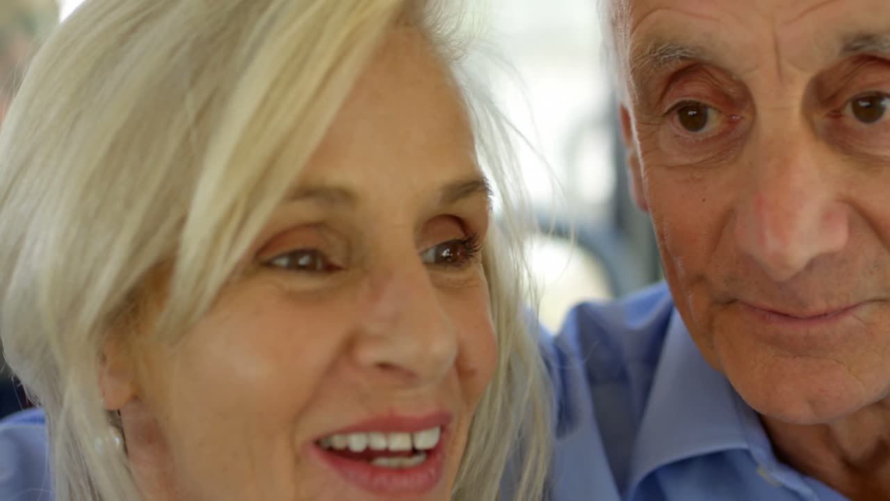 Senior couple interacting with each other while travelling in bus 4k