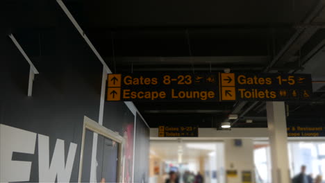 busy airport sign interior with gates toilets and lounge bustling with travellers