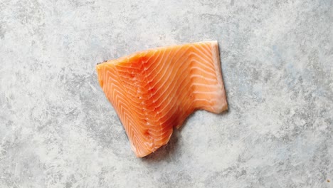 carne de salmón fresca cruda colocada sobre fondo de piedra gris