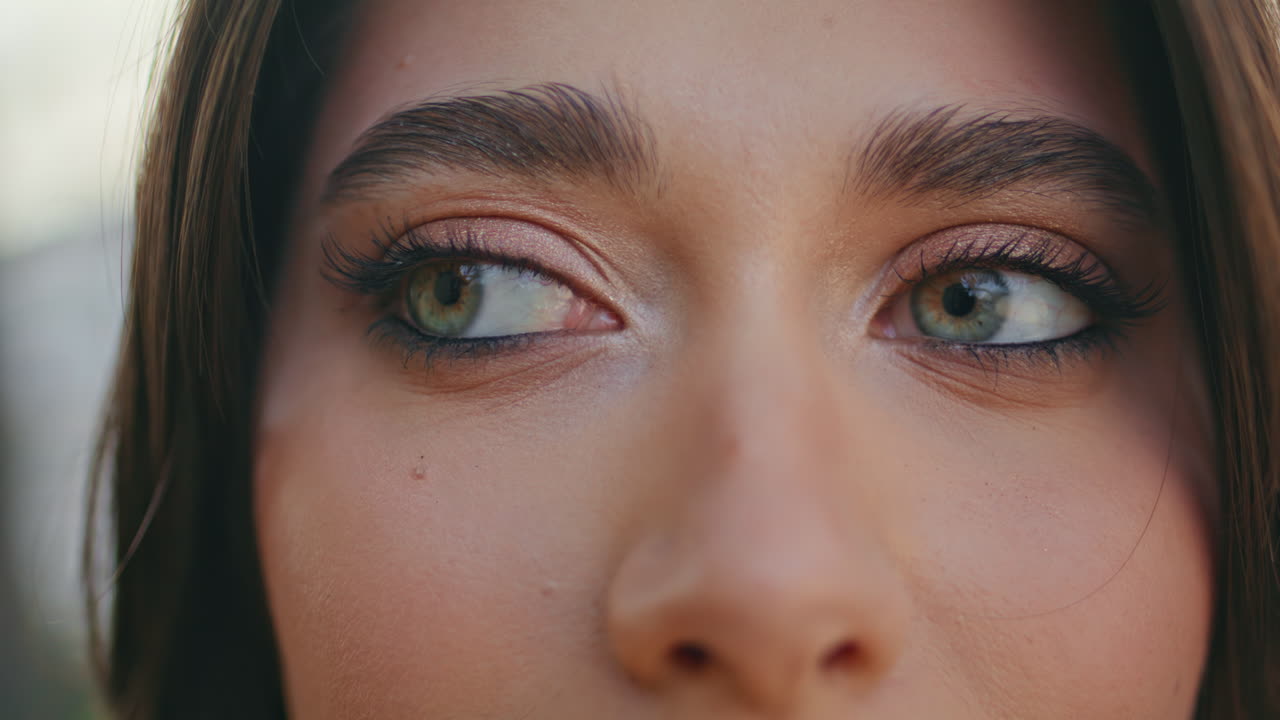 Green eyes girl looking camera adjusting hairstyle at nature closeup. Lady face