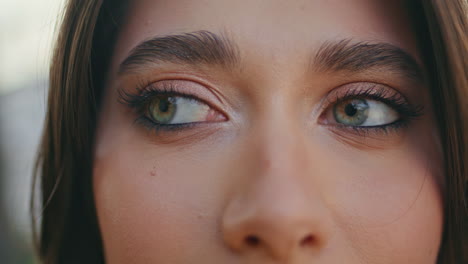 green eyes girl looking camera adjusting hairstyle at nature closeup. lady face