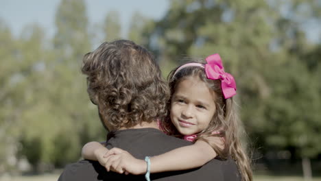 back view of father carrying daughter in arms