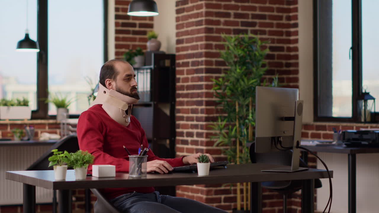 Male employee with foam neck collar working on business growth