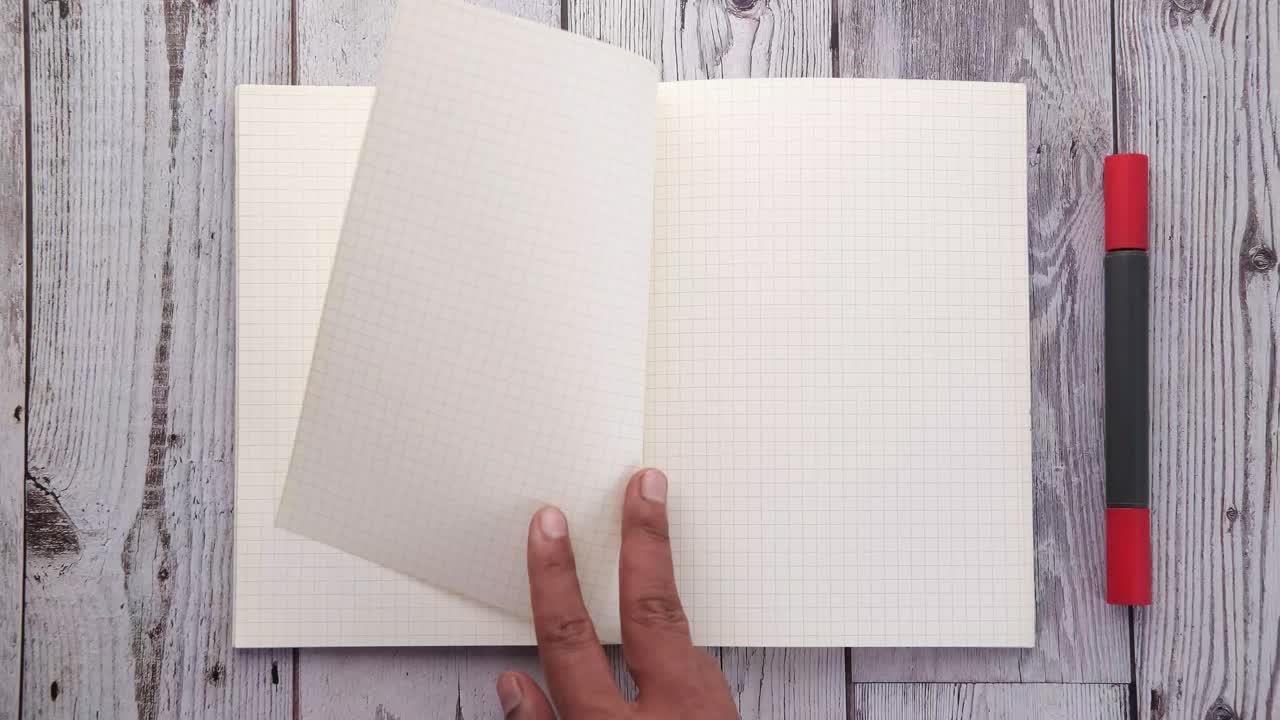 Open Notebook with Marker on Wooden Table