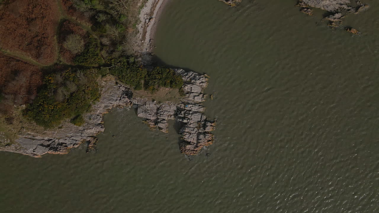 вид сверху вниз на туриста на скалистом выступе в мутном море в дженни браунс поинт сильвердейл великобритания