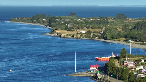 Luftaufnahme-Eines-Ruhigen-Chacao-Küstendorfes-Mit-Blauem-Wasser-Und-Verstreuten-Häusern-Entlang-Der-Küste