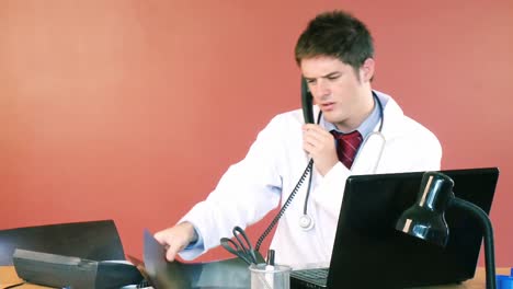 Attractive-doctor-on-phone-examining-an-xray-in-hospital