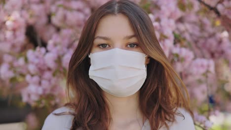 woman wearing a mask in a cherry blossom tree