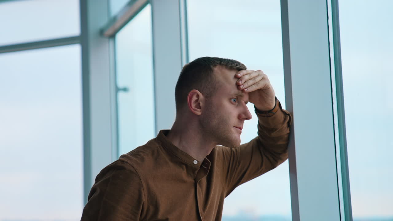 Young businessman looking through the window