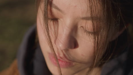 close-up of a girl's face with her eyes closed, her expression deeply unhappy and sorrowful. her hair partially covers her face, adding to the sense of melancholy and introspection