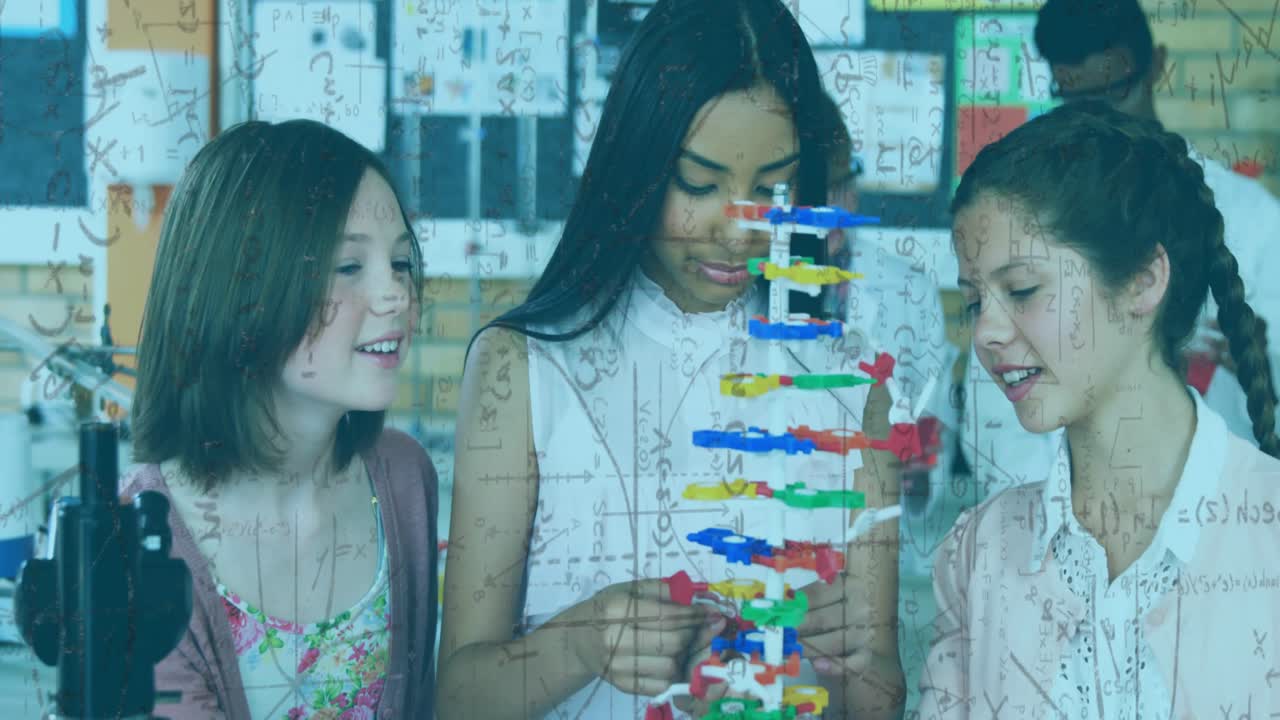 Tre studenti, con lo studente centrale che inizia l'assemblaggio e regola un modello di DNA colorato per la lezione di scienze.