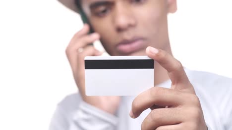 hombre con tarjeta de crédito y hablando por teléfono