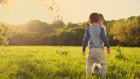 two cute little kids playing football together summertime. children playing soccer outdoor