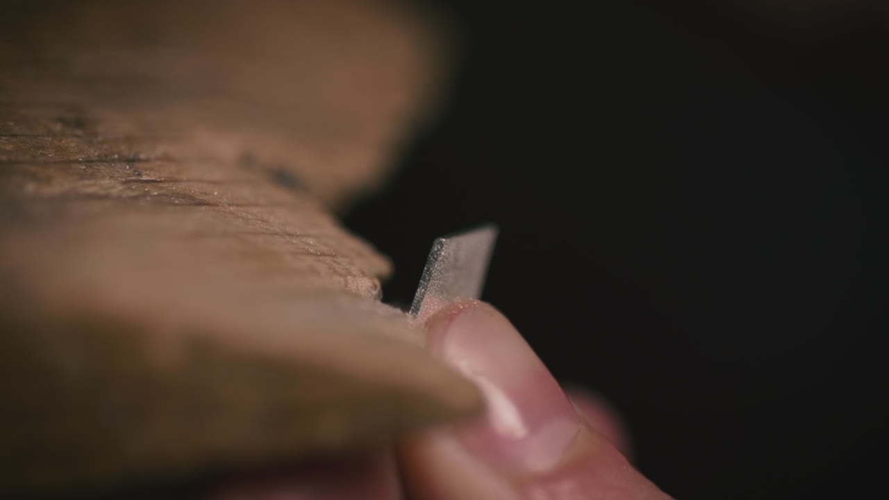 A person uses a file to smooth metal and wood