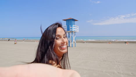 brunette woman taking self portrait on beach