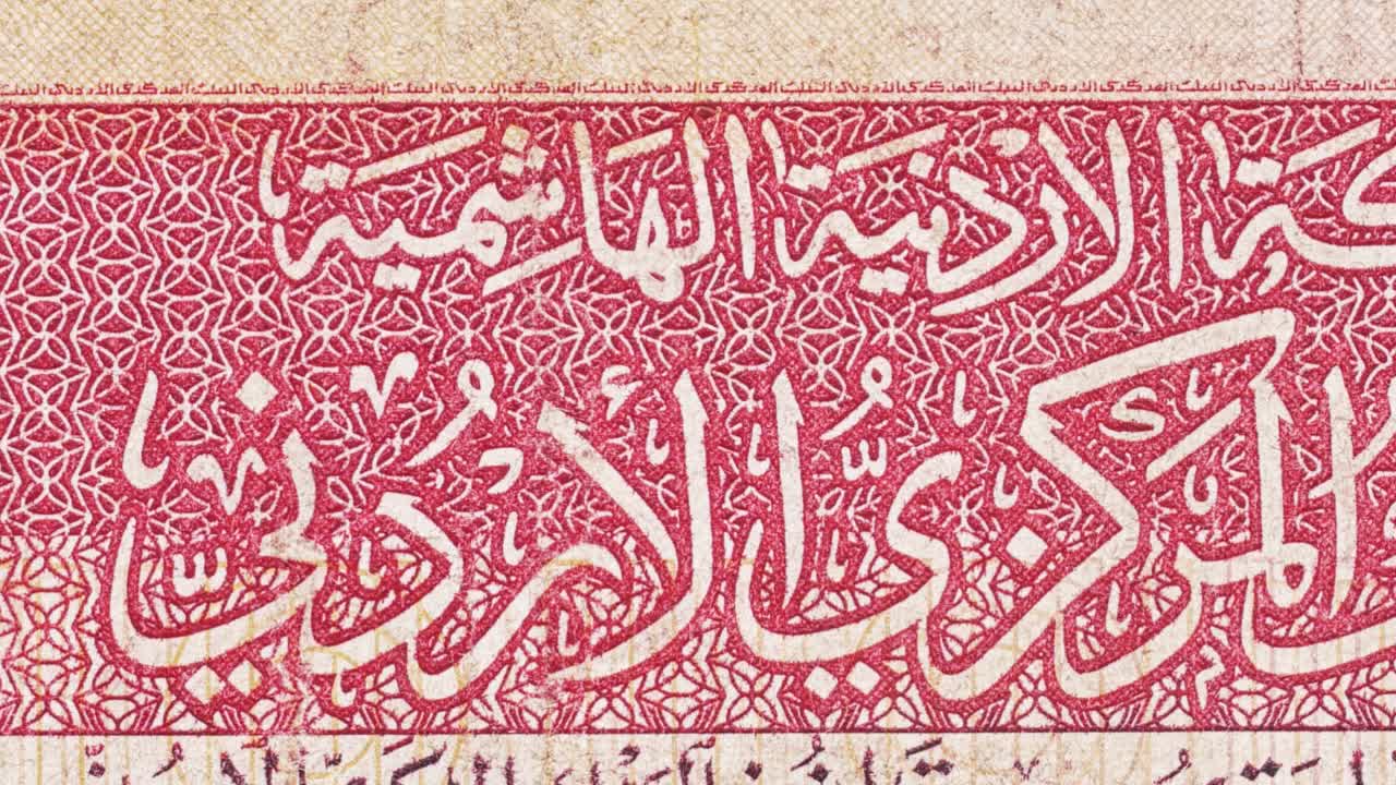 Macro pan over a Jordanian dinar showing Central Bank Arabic text and red geometric guilloche