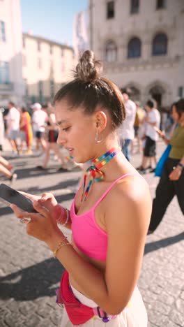 woman at a pride parade using her phone