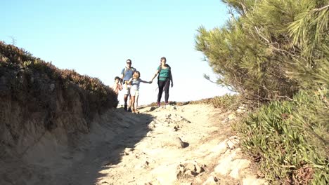 parents and kids walking on path downhill at countryside