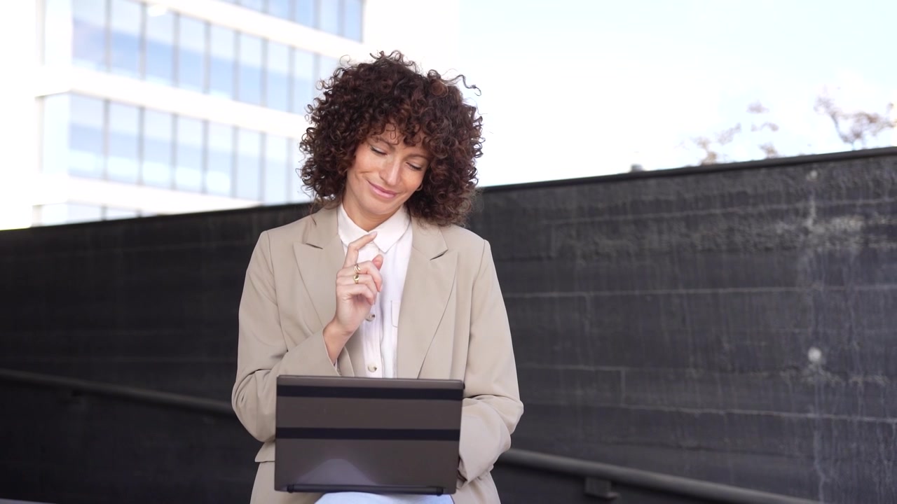 A businesswoman working on her laptop in a vibrant urban setting fully engaged in her tasks