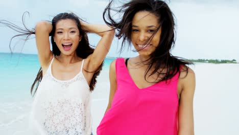 portrait of happy multi ethnic girlfriends on beach