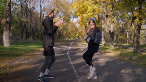 pareja haciendo ejercicio y estirándose en el parque de otoño