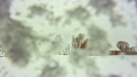 Toma-De-Tiempo-De-Una-Cabaña-De-Madera-En-Medio-De-Una-Nevada-Con-Una-Cámara-Cubierta-De-Nieve-En-Un-Frío-Día-De-Invierno