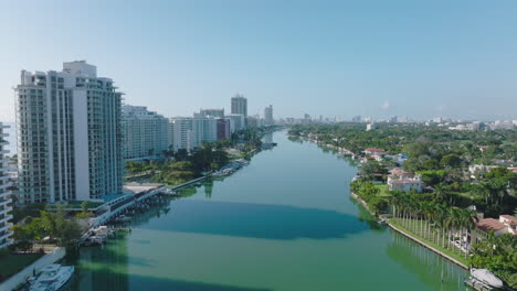 Aerial-descending-footage-of-luxury-residential-borough-in-tropical-area.-Buildings-on-creek-waterfront.-Miami,-USA
