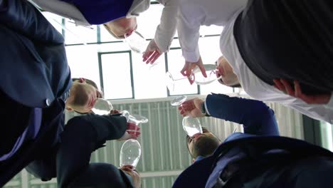 businesspeople toasting a glasses of wine in office