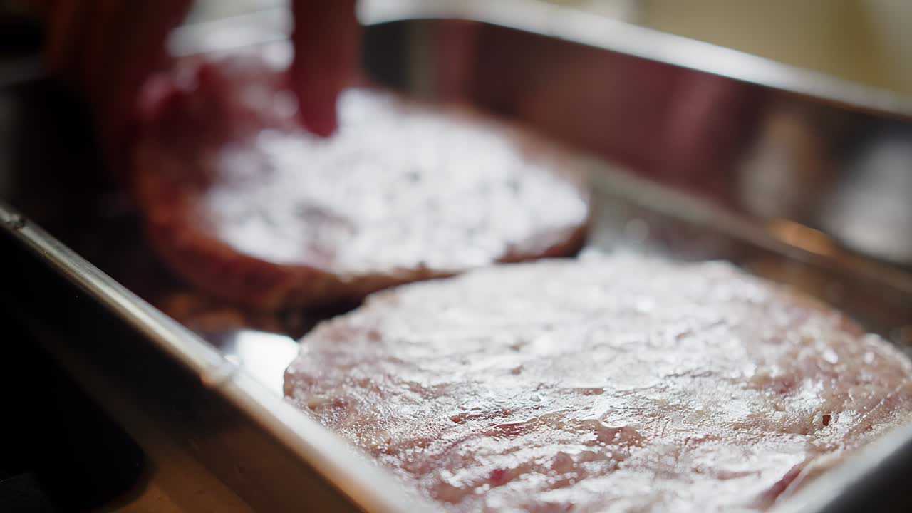 매크로 클로즈업 는 향신료 향신료 소금은 신선한 원시 버거 고기 고기 위에 떨어집니다.