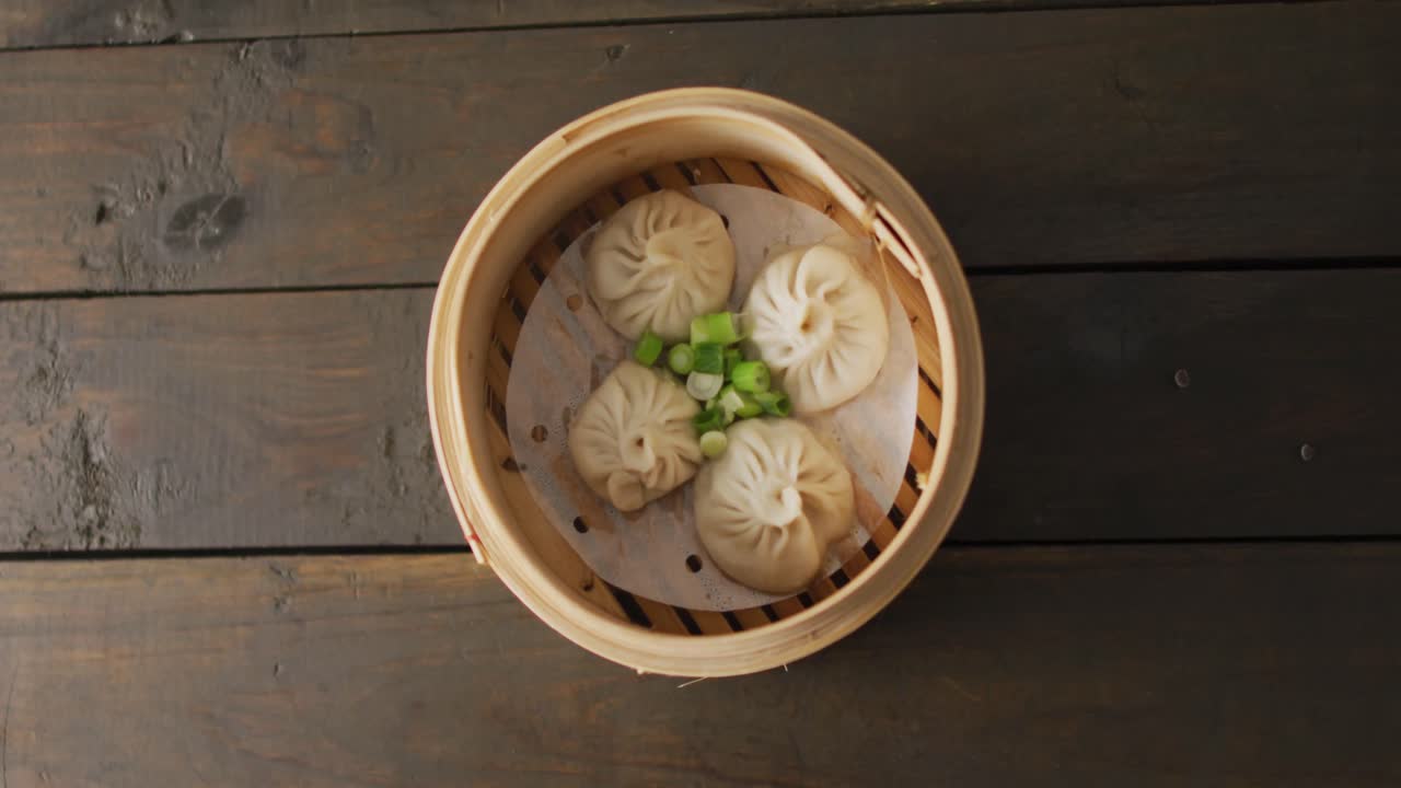 나무 배경에 dim sum dumplings와 함께 대나무 증기기의 구성