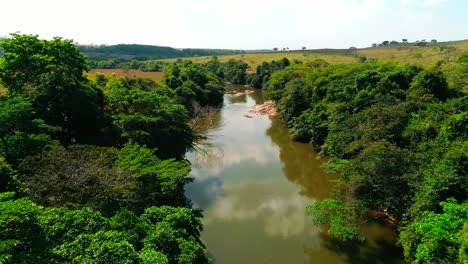 Tiro-Aéreo-De-Vuelo-Rápido-Sobre-Un-Río-En-El-Campo-Rural