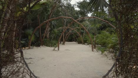 movimiento del dron hacia atrás de una cabaña natural en una playa entre palmeras en la jungla
