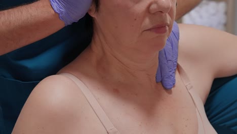 woman undergoing shoulder and neck adjustment by therapist in clinic