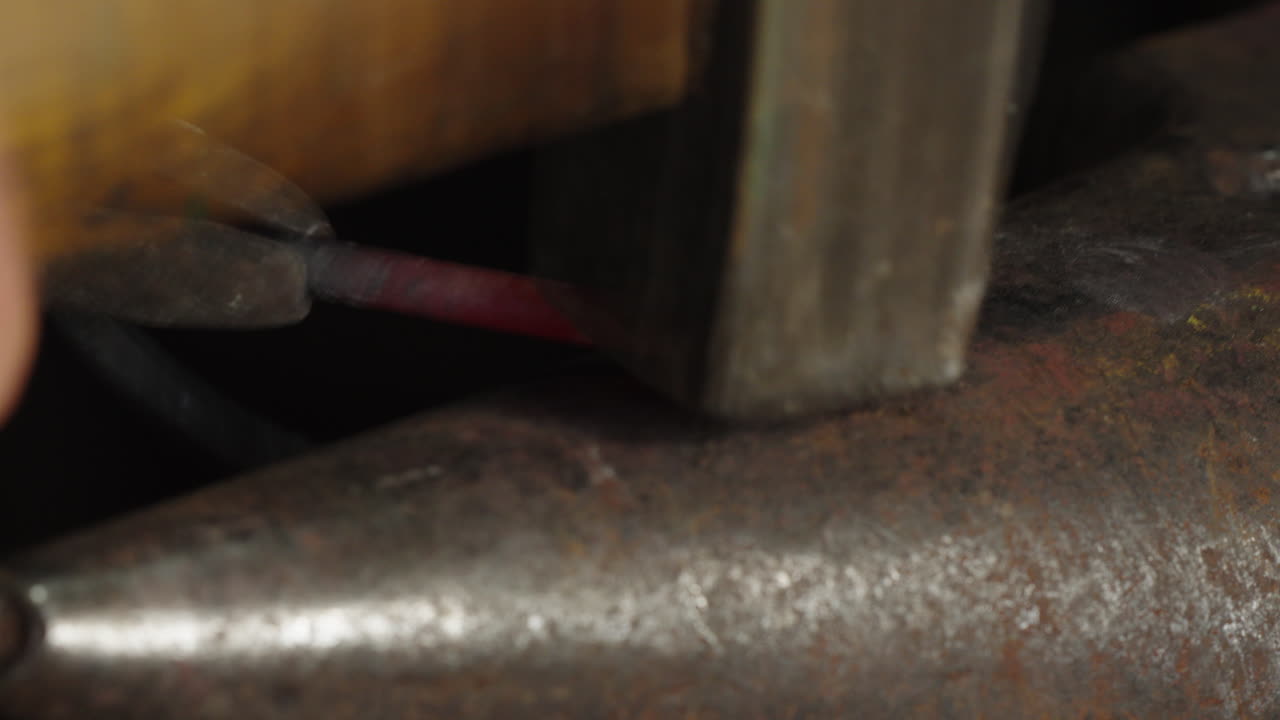 primer plano de una pieza de metal, martillado en el yunque