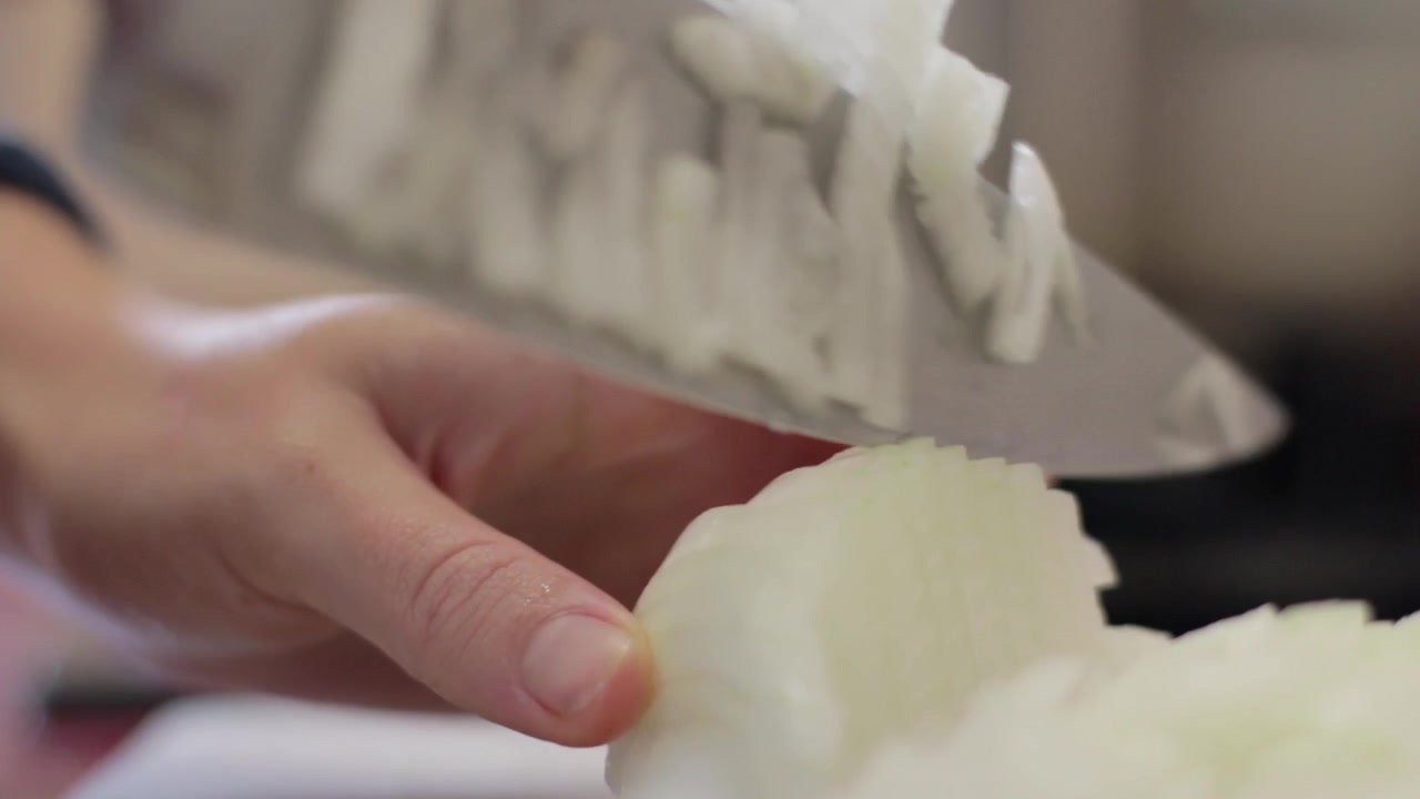 Cutting onion in dices with a big knife