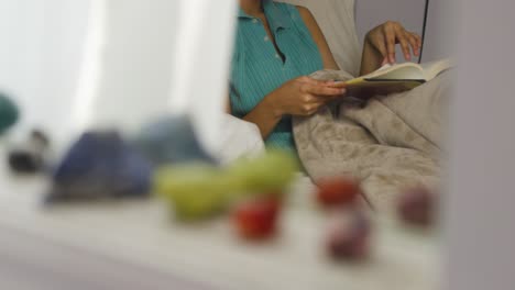 young brown woman reads and closes book