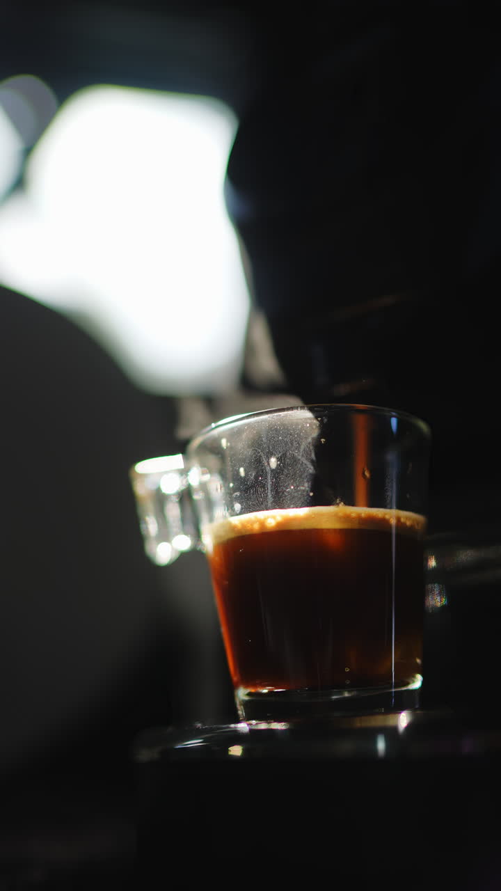 Primo piano di caffè espresso caldo fumante in tazza di vetro