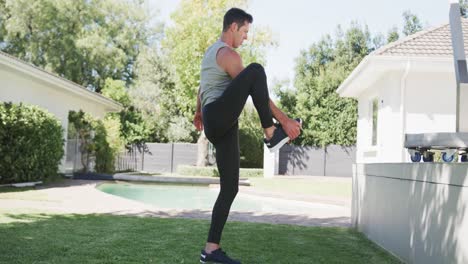 hombre caucásico practicando yoga en un jardín soleado, cámara lenta