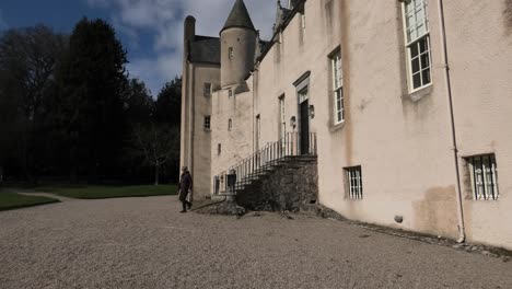 Drum-Castle,-Am-Frühen-Frühlingsmorgen,-Kommt-Die-Dame-Die-Vordertreppe-Herunter