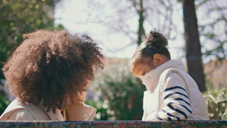 mother looking daughter tenderness relaxing outdoors close up. lovely family