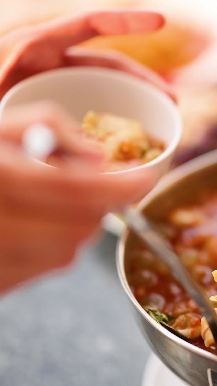 echando sopa en un cuenco en una mesa