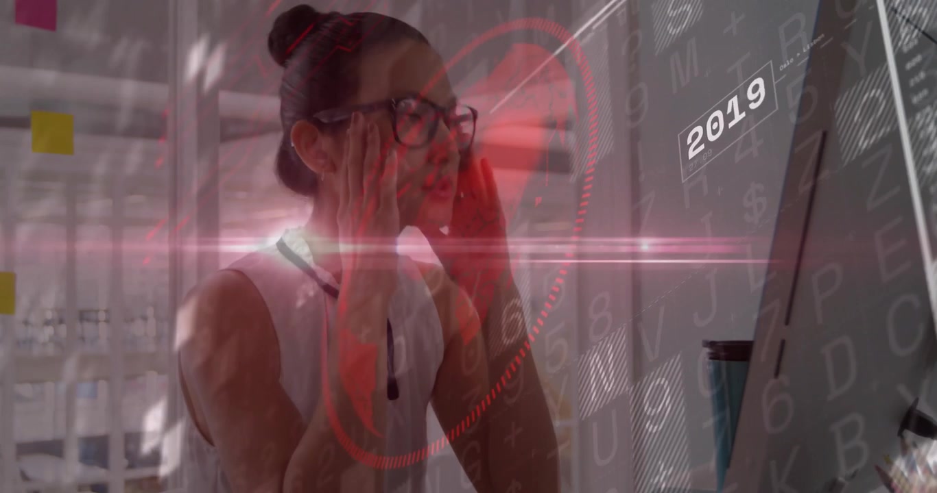 Mujer profesional en un escritorio reaccionando a los cambios en los marcadores de datos anuales, frotándose los ojos y luego reenfocando la pantalla.