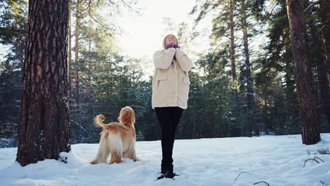 woman and dog in a snowy forest