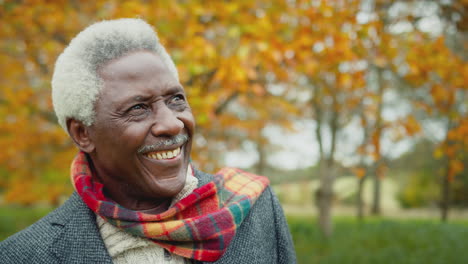 head and shoulders portrait of senior man on walk through autumn countryside - shot in slow motion