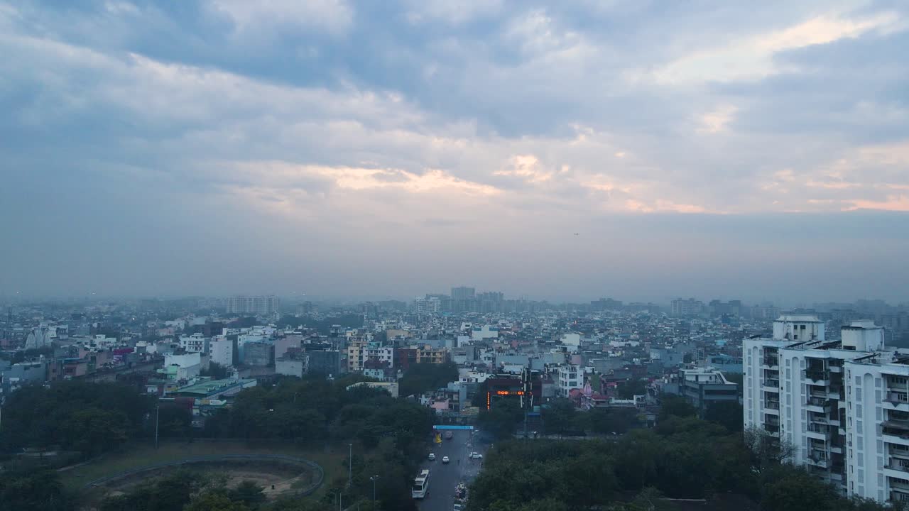 Aerial drone shot offering a breathtaking view of Delhi’s urban skyline bathed in the tranquil blue light of early morning, with a mix of modern and historic architecture.