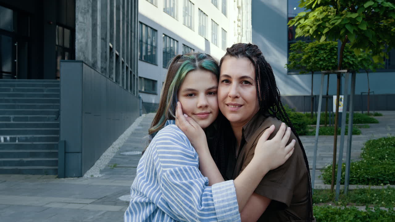 madre e hija se abrazan al aire libre